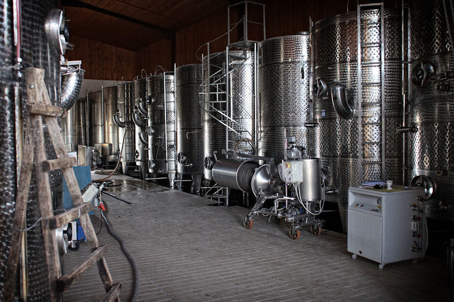 lying aluminum wine storage tanks on the one side of 'Domaine Migas' plant